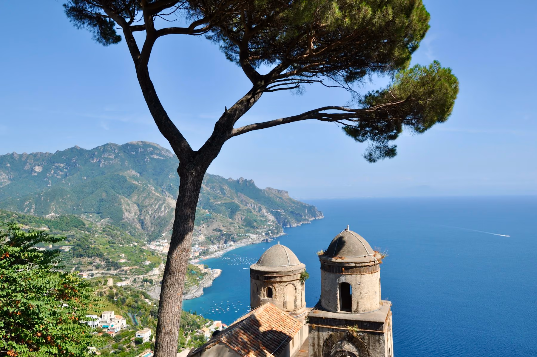 An umbrella pine and the domed towers of Villa Rufolo in Ravello above the Amalfi Coast