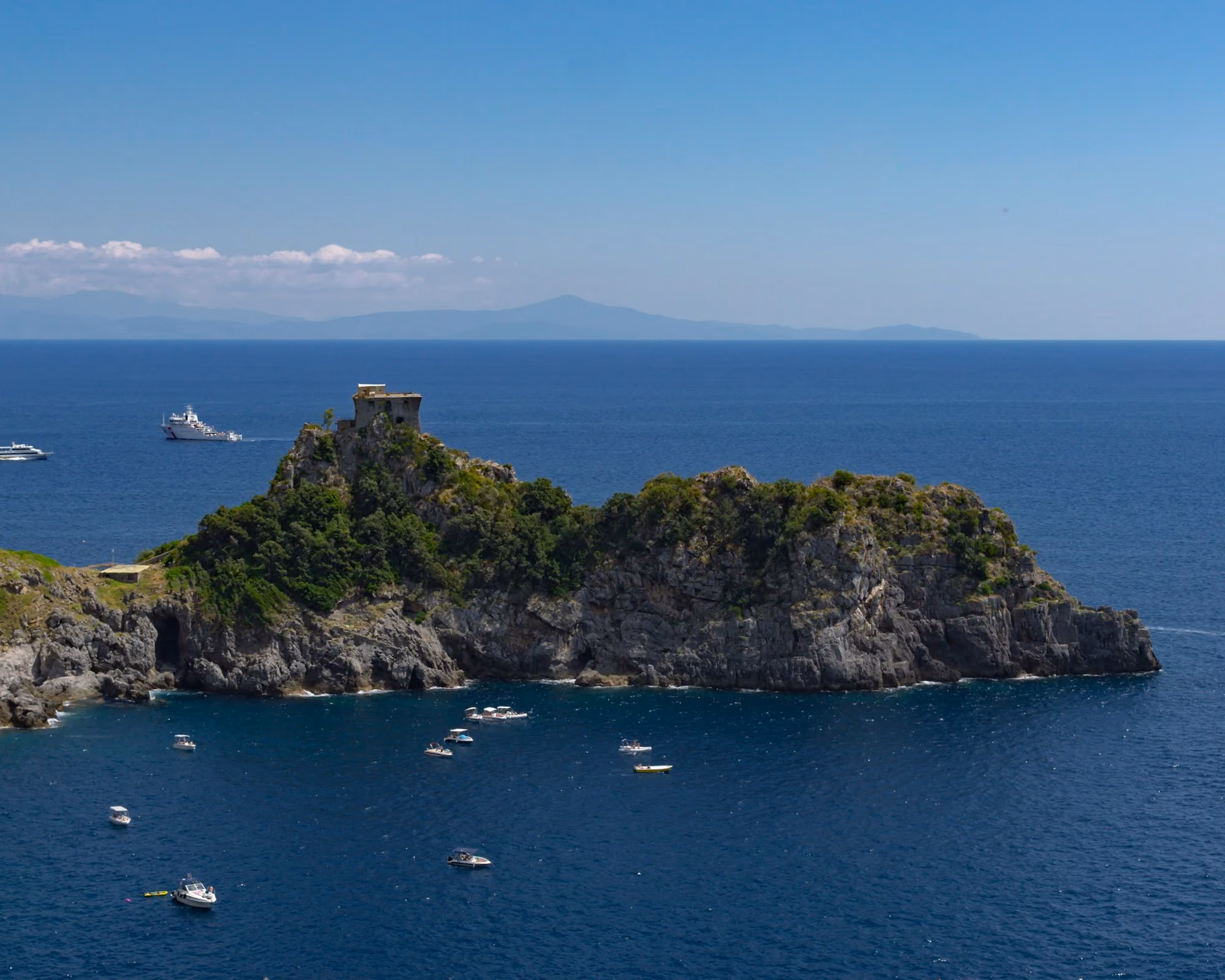 Near Monastero Santa Rosa Hotel & Spa: a rocky island with boats with Isola Bella in the background