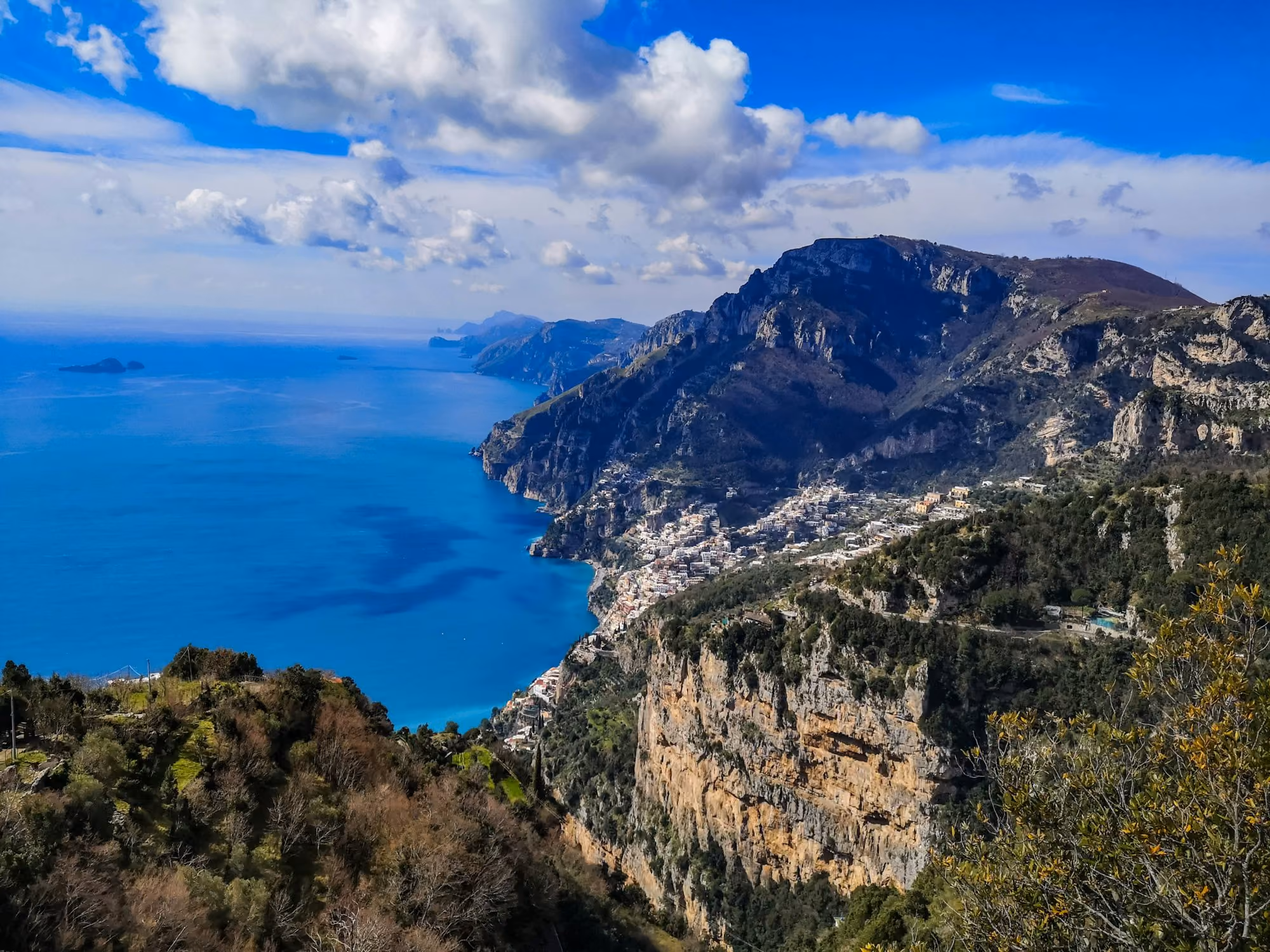 Near Villa Treville: green and brown mountain beside blue sea under blue sky during daytime