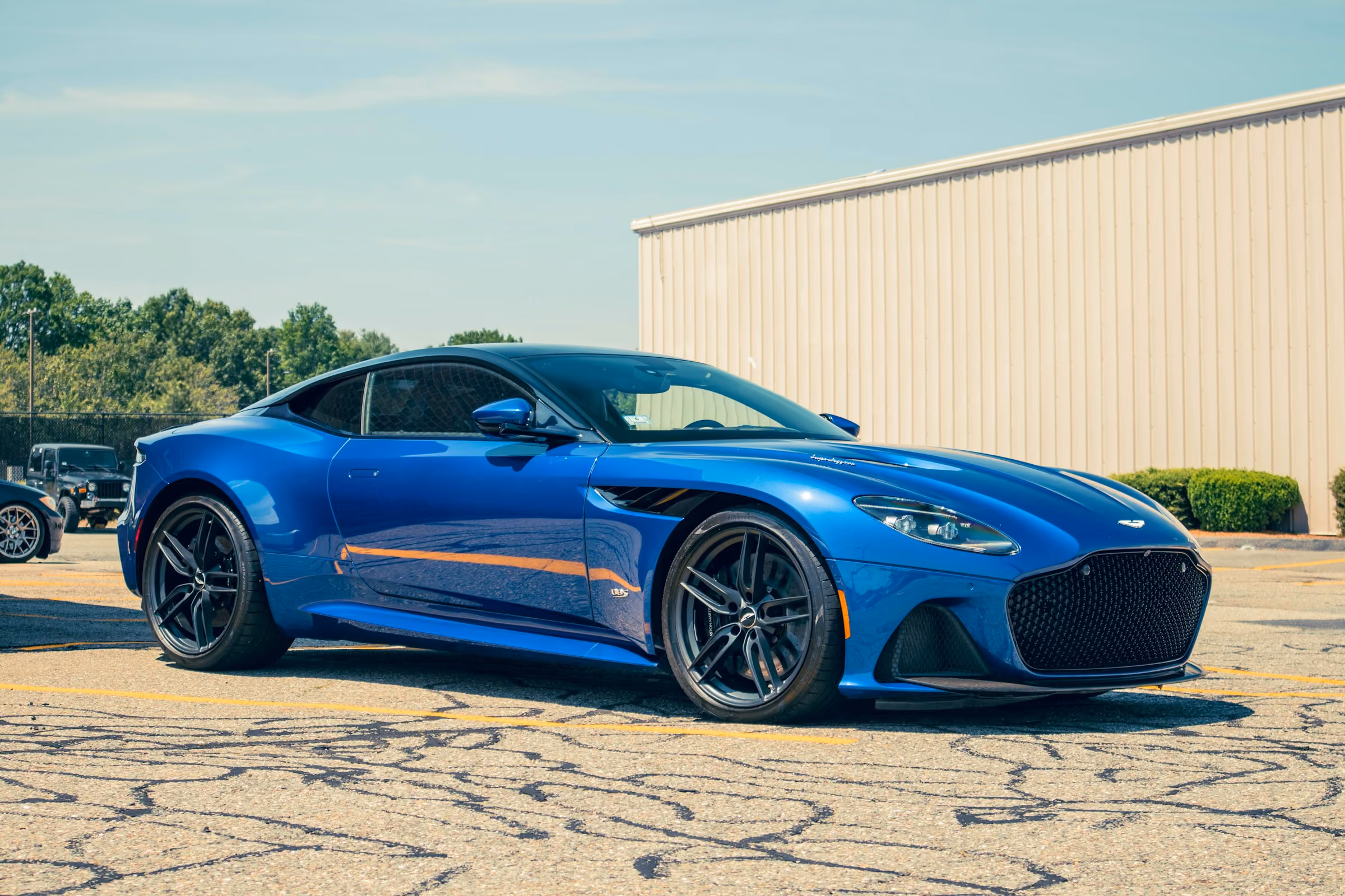 A blue Aston Martin parked in the sun