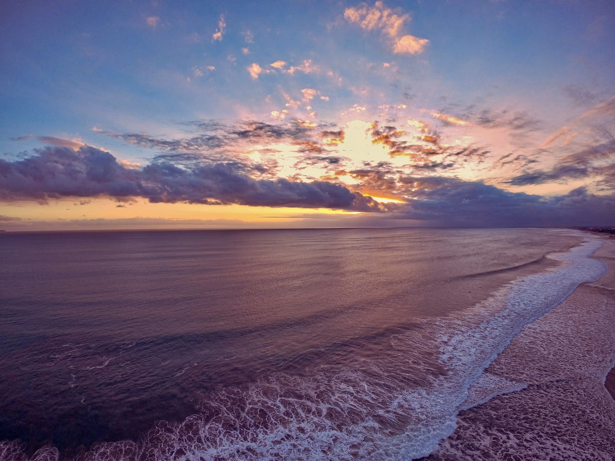 Near Desa Potato Head Bali: sea waves crashing on shore during sunset