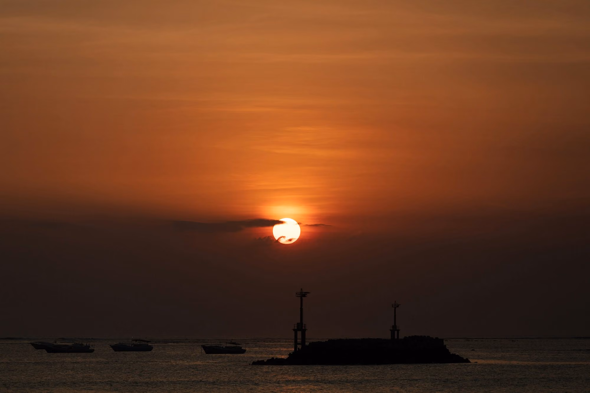 Near Raffles Bali: boats on sea during sunset