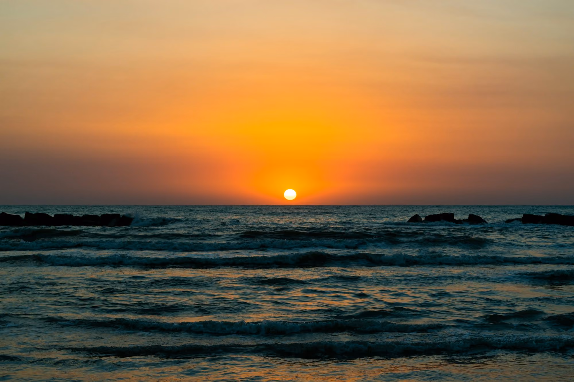 Near Tandjung Sari: sea waves crashing on shore during sunset