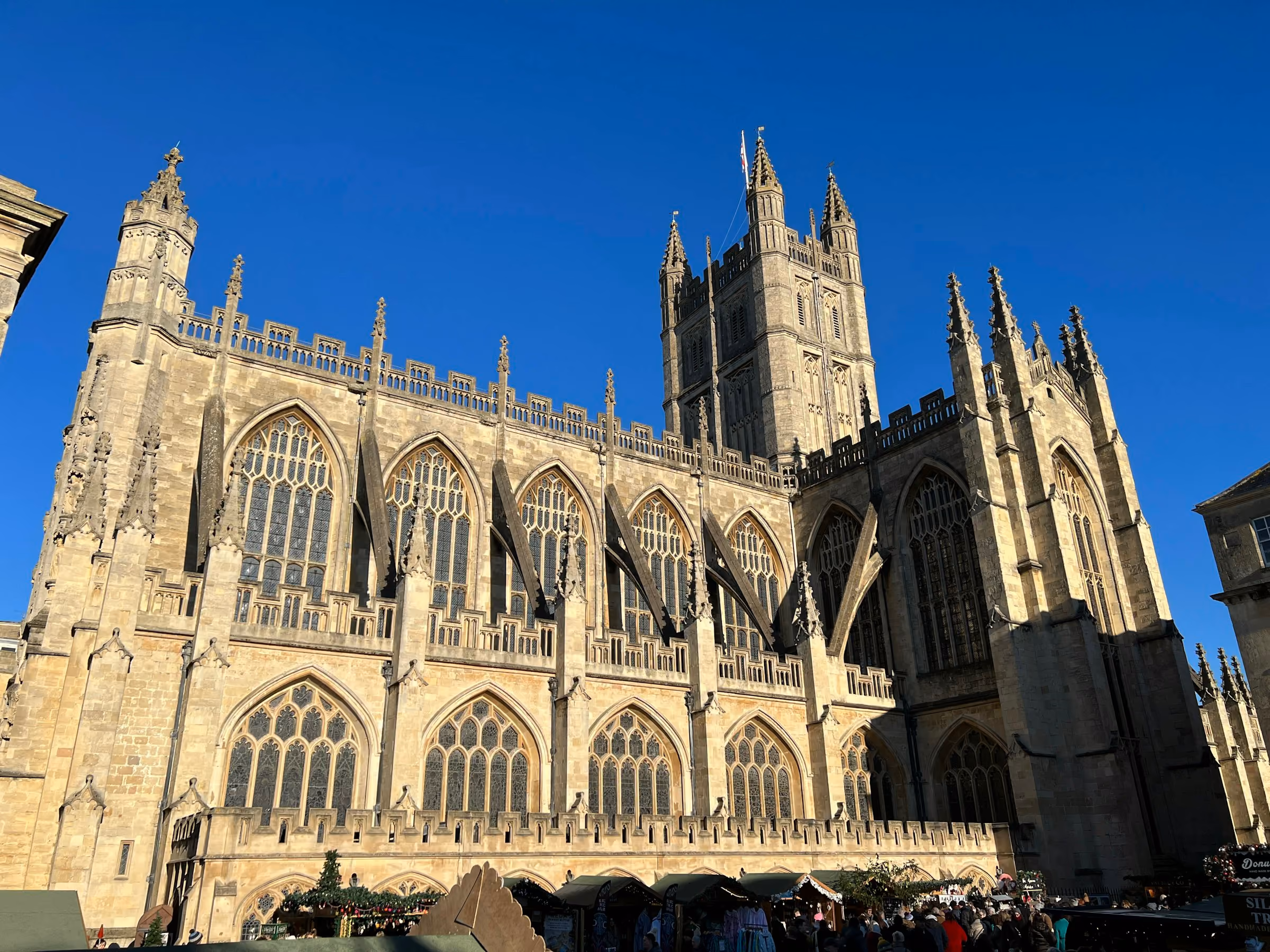 The west front of Bath Abbey against a deep blue sky
