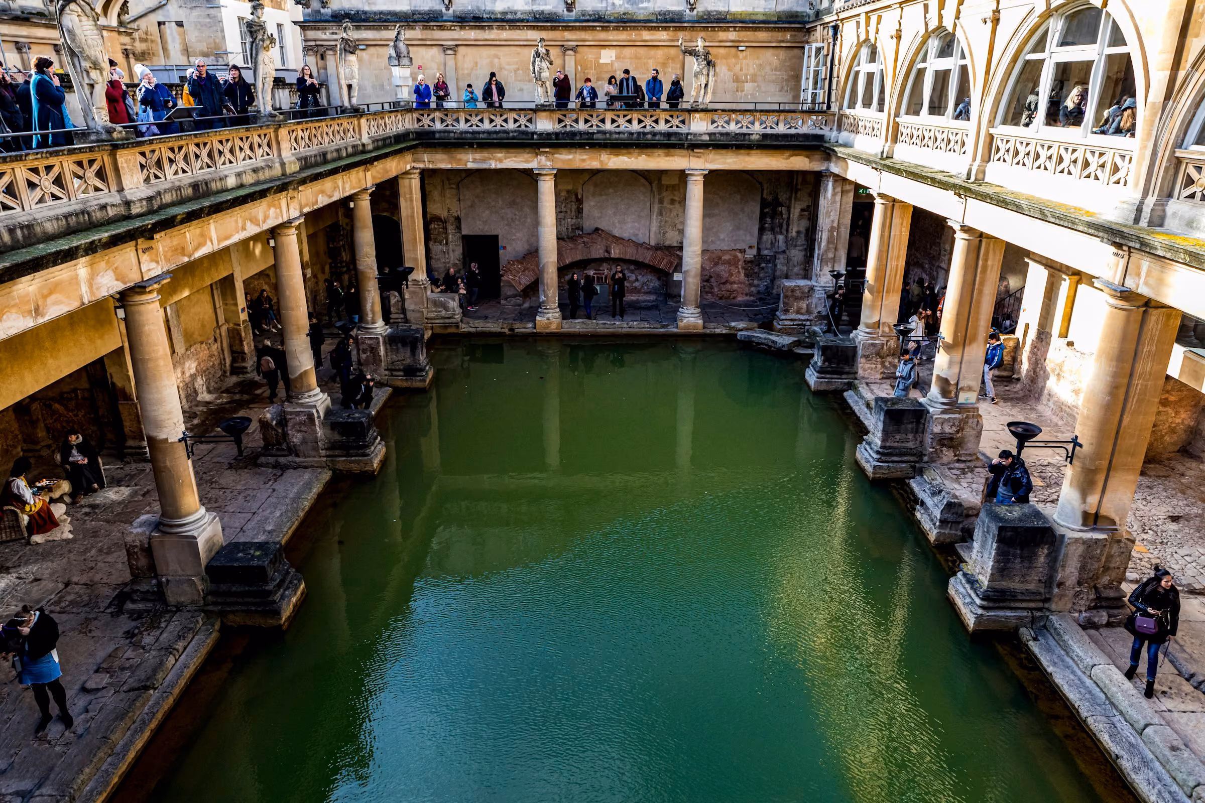 The Great Bath at the Roman Baths, green water framed by stone columns