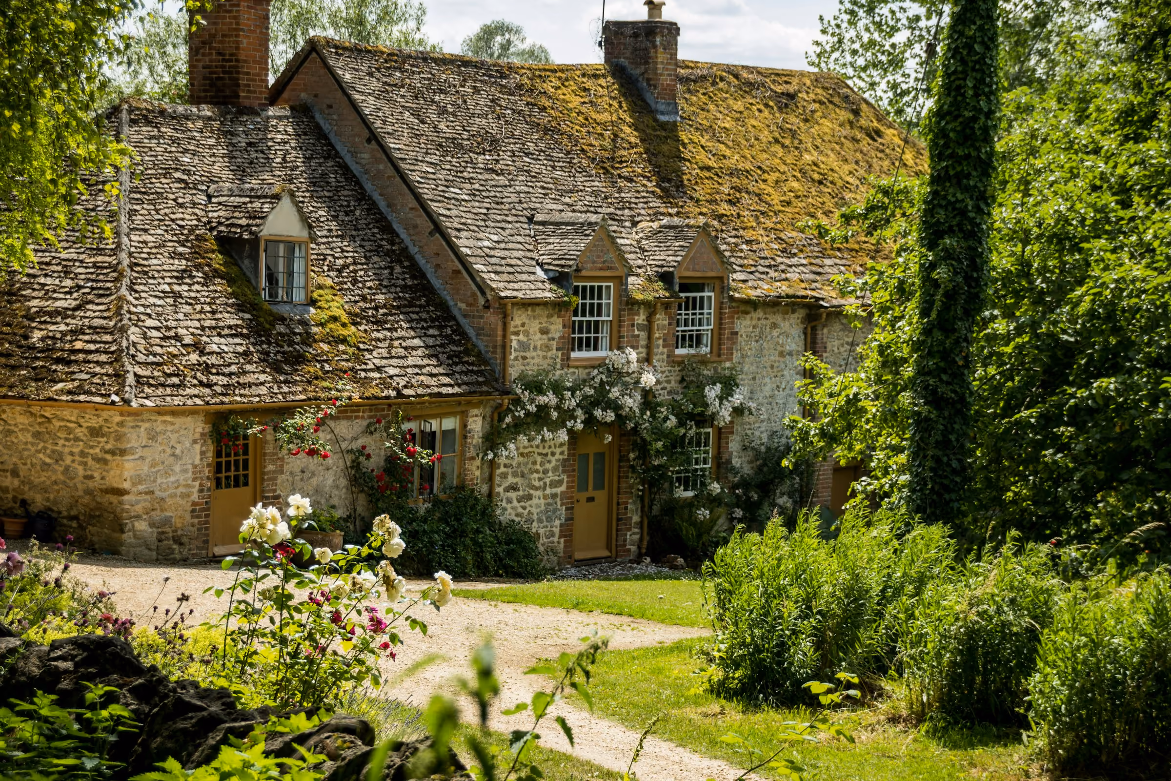 A Cotswold stone cottage with a cottage garden in summer