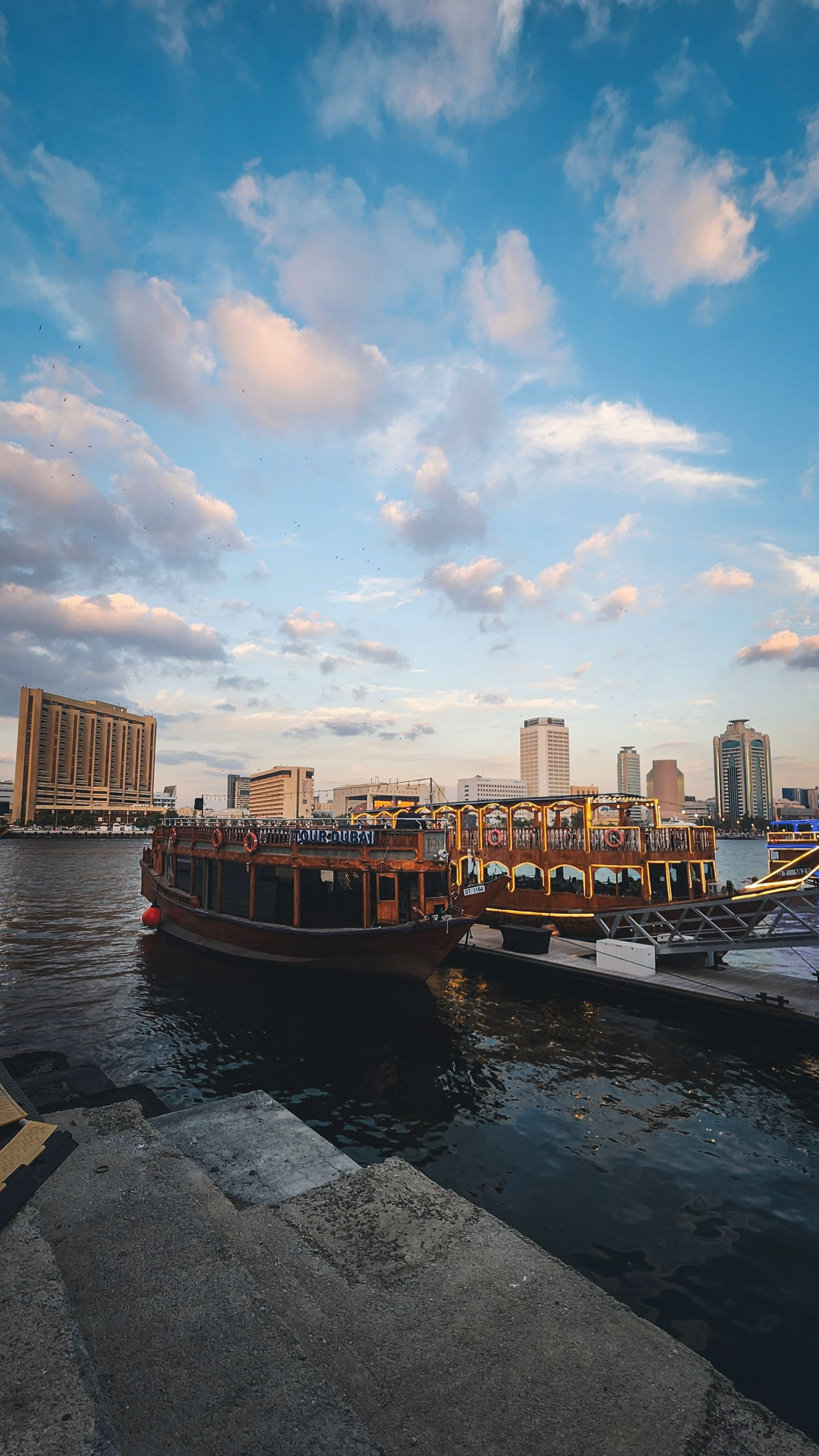 Traditional wooden dhows moored on Dubai Creek at Al Seef as evening falls
