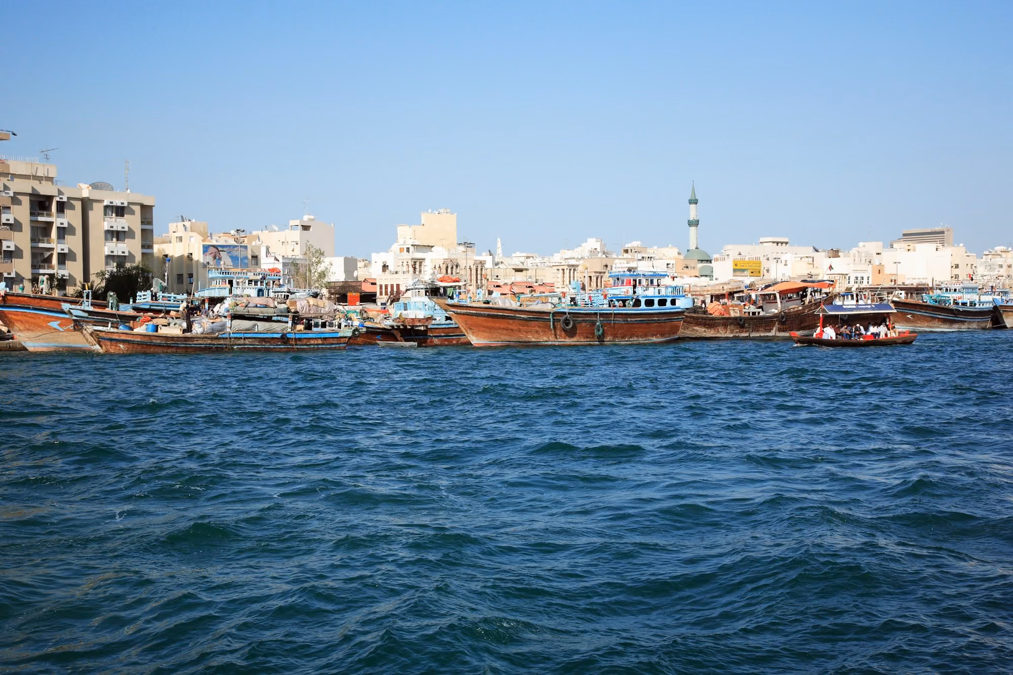 Near Address Creek Harbour: brown boat on sea near city buildings during daytime