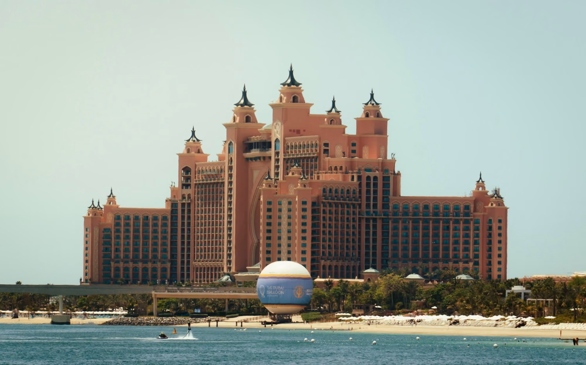 A large building sitting on top of a beach next to the ocean