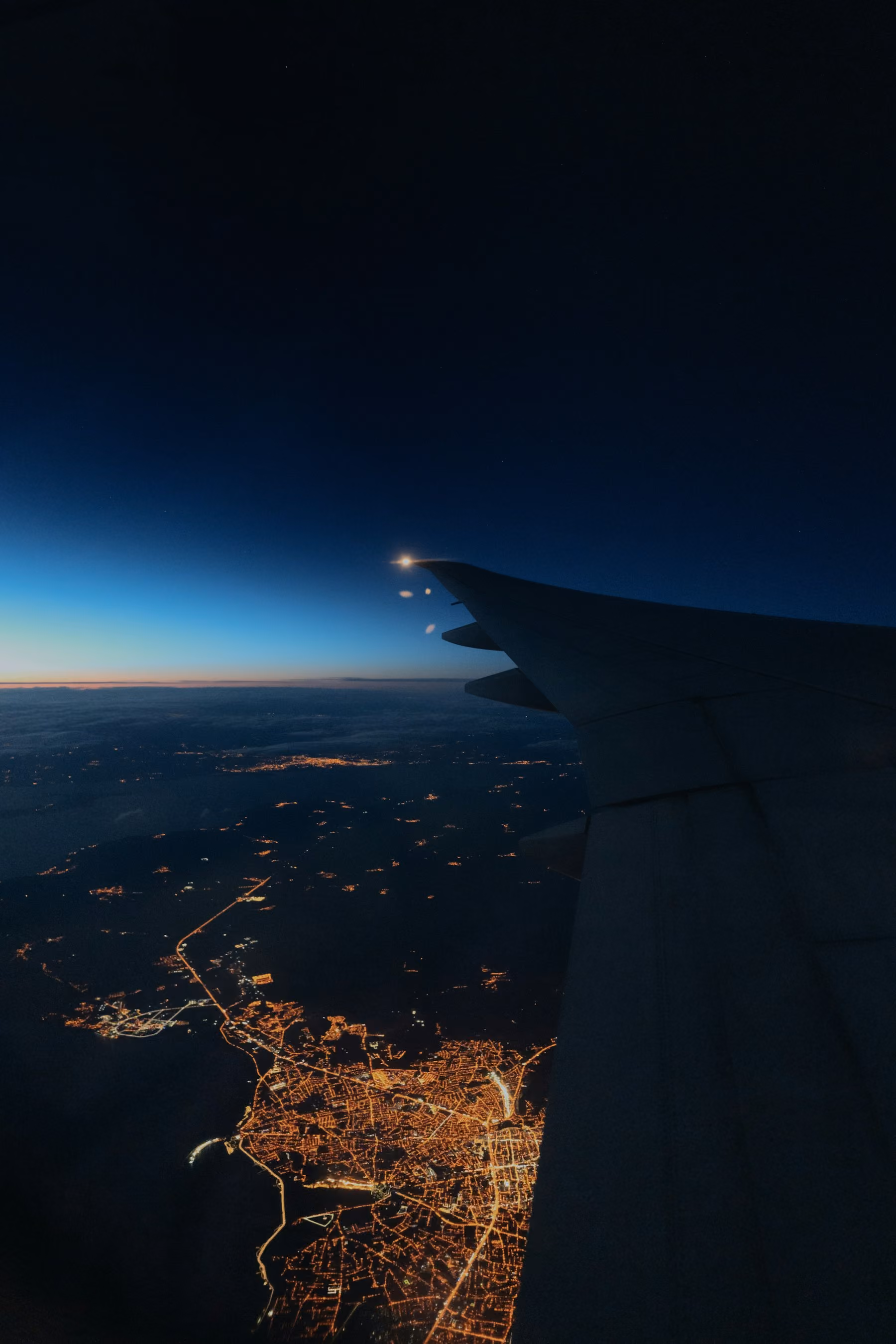 City lights seen from an aircraft window on the descent
