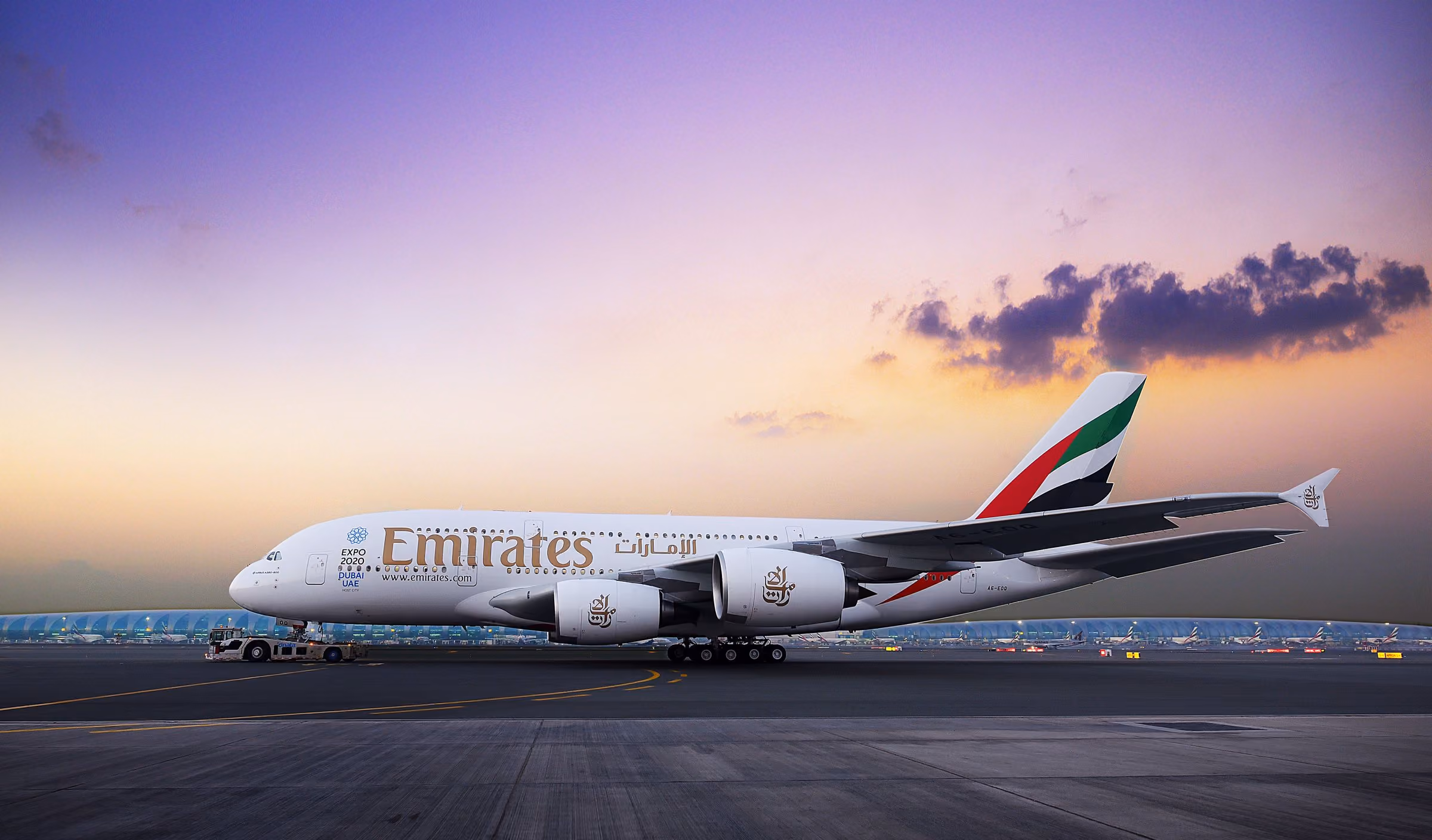 An Emirates A380 on the ground at dusk