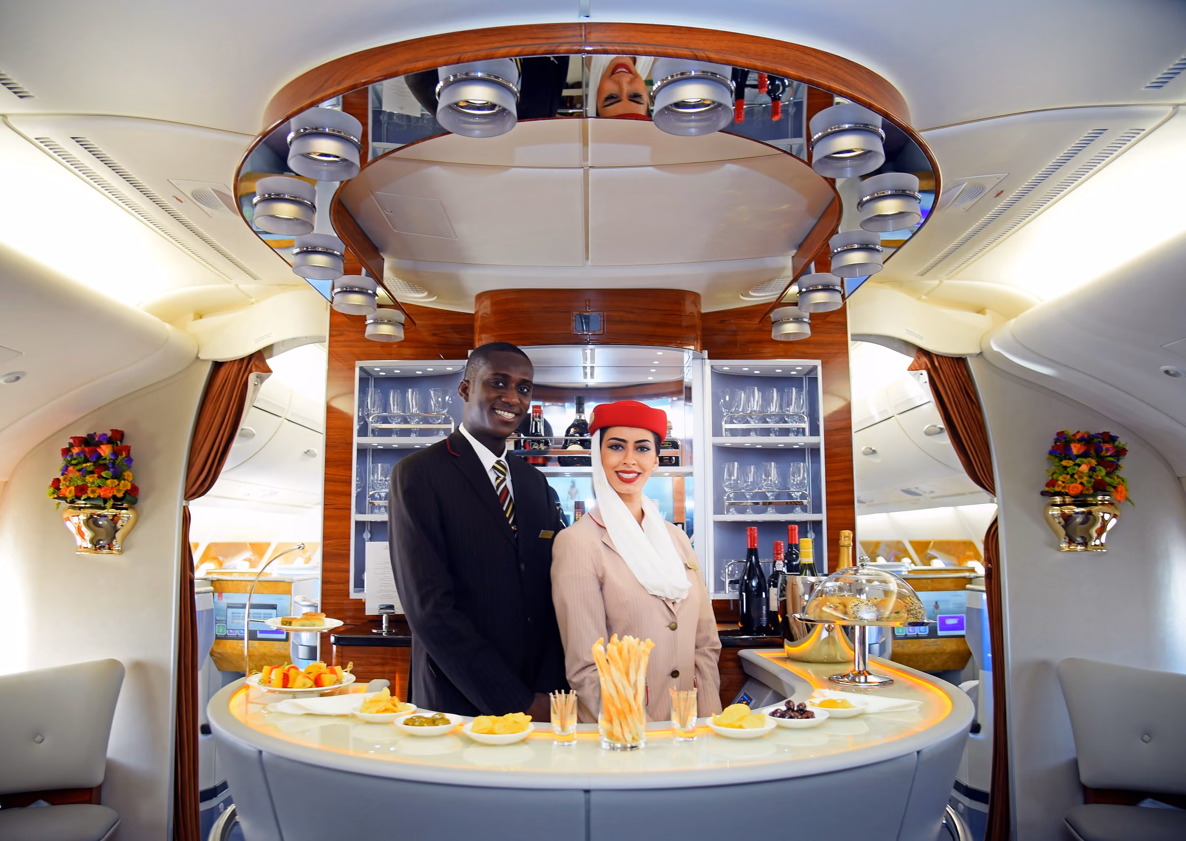 Cabin crew behind the bar, in the Onboard Lounge on the Emirates A380 upper deck