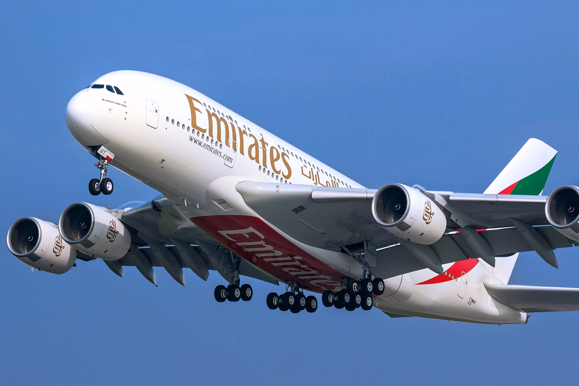 An Emirates A380 climbing after take-off, landing gear still down