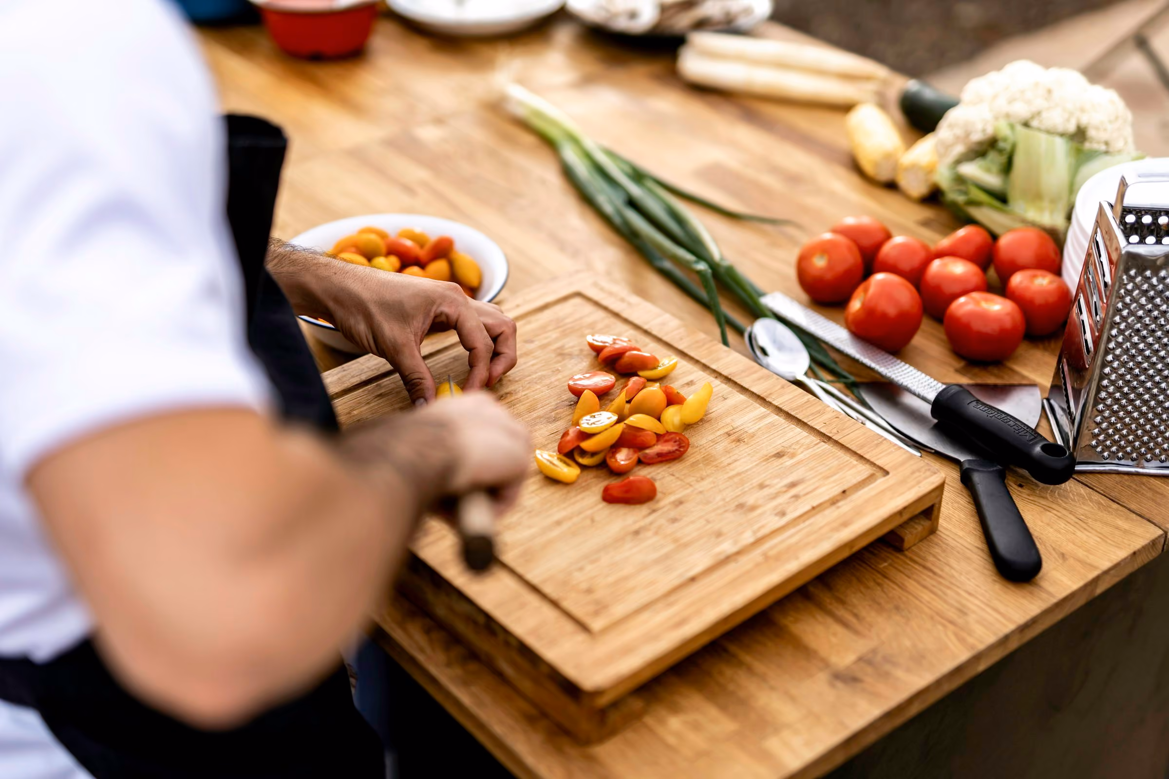 Vegetables and a knife on a chopping board in a cookery class