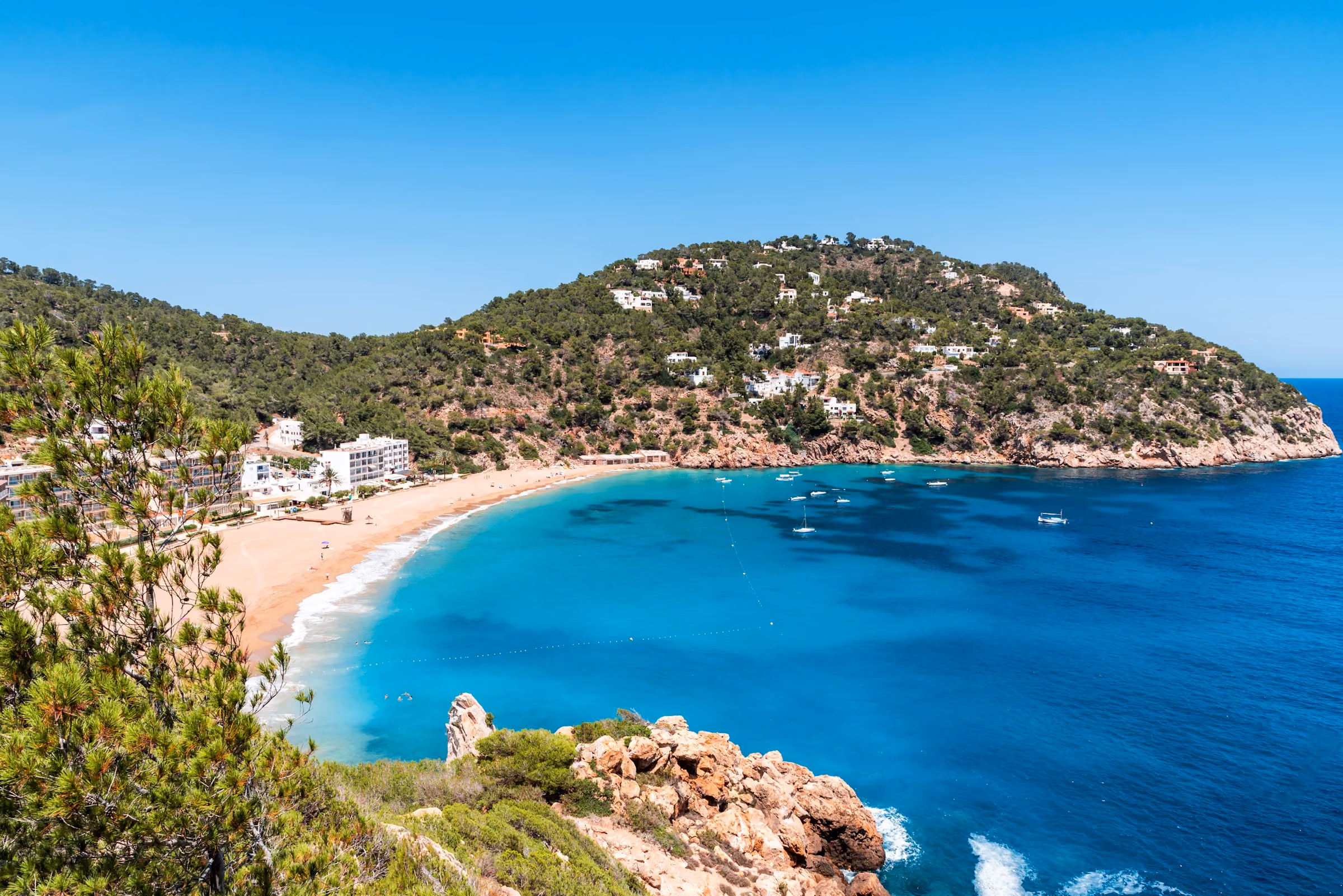 A turquoise cala on Ibiza's coast with a small beach
