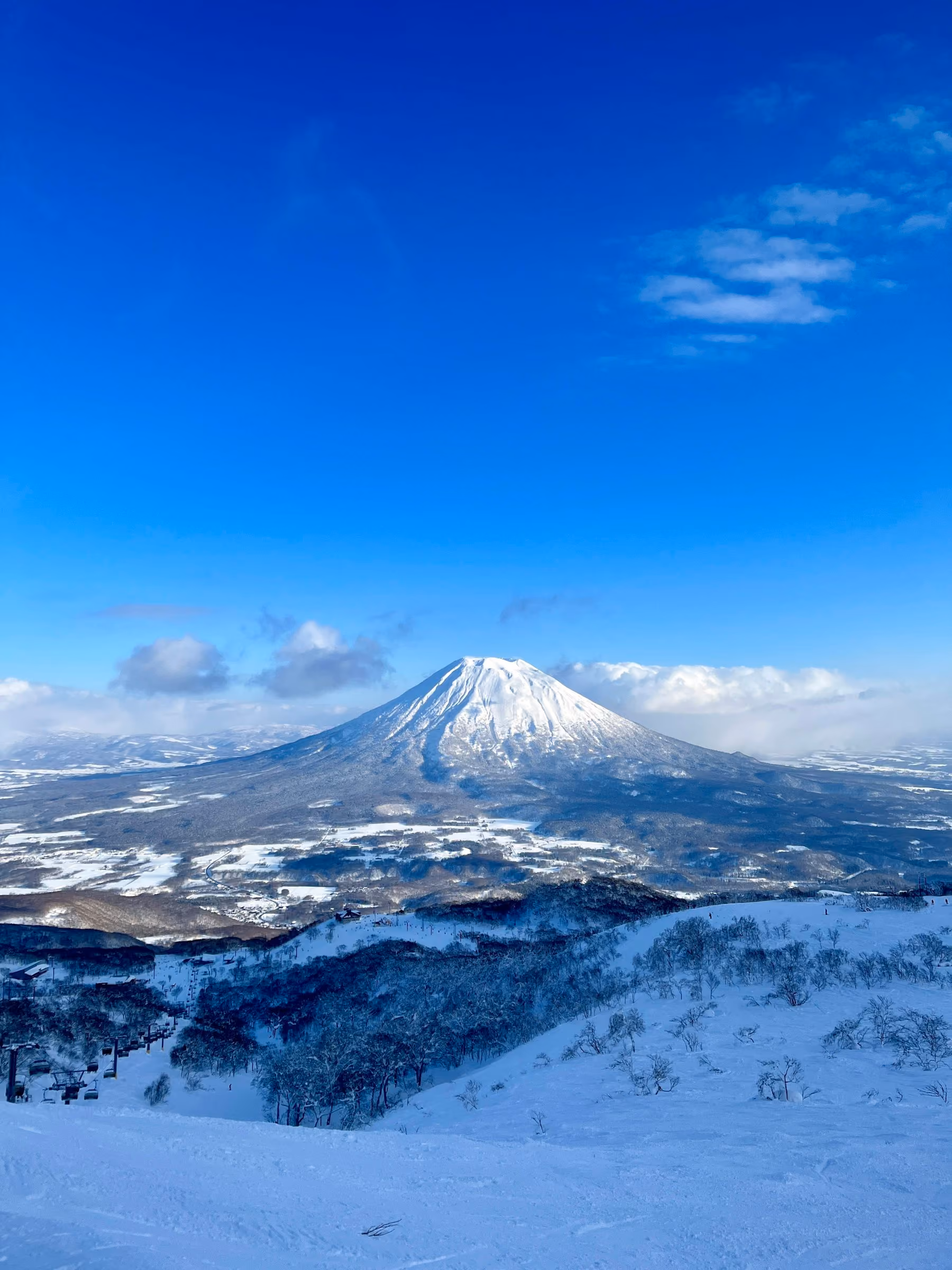 Snow-covered Mount Yotei seen from the slopes of Niseko under a clear blue winter sky