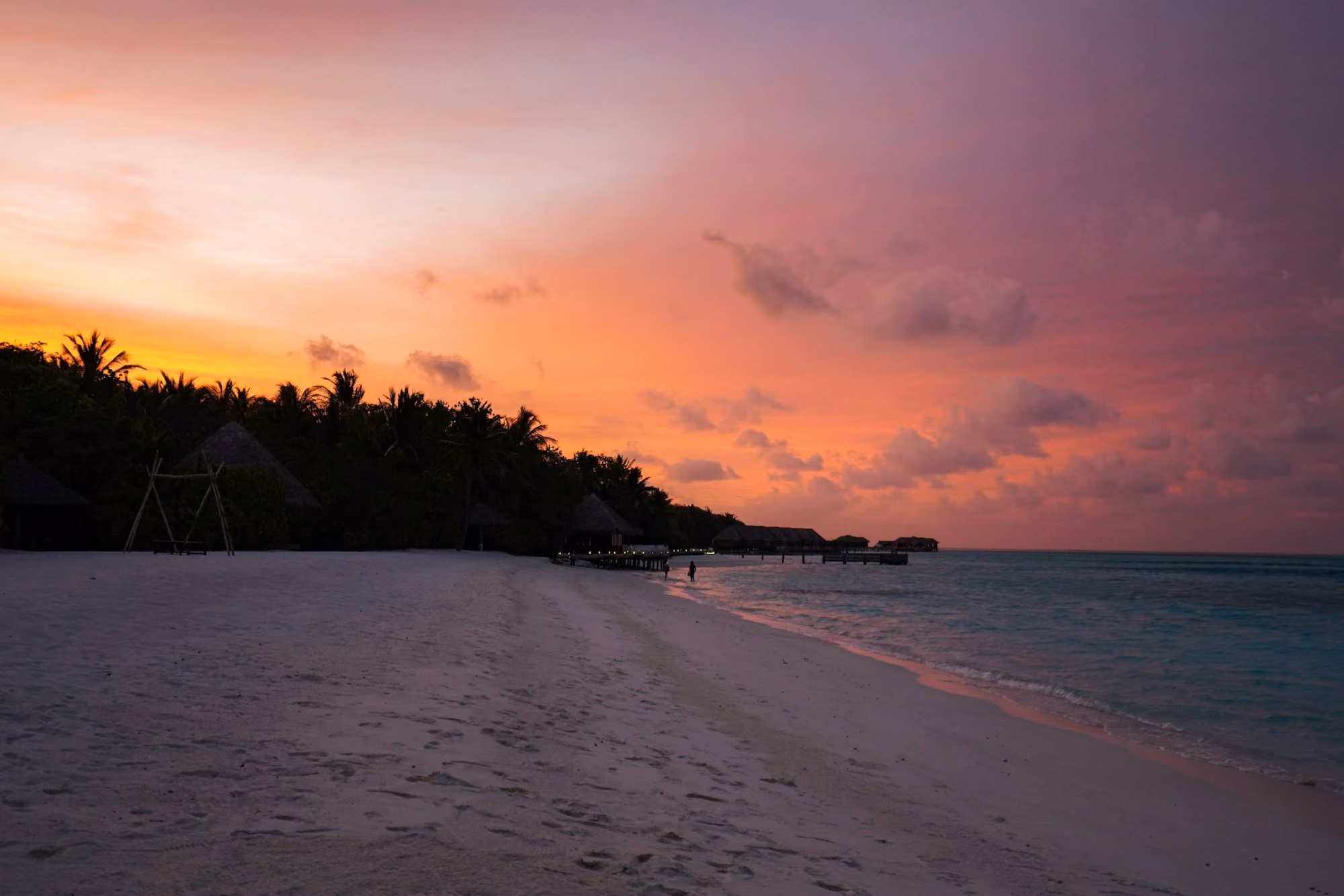 Near Patina Maldives, Fari Islands: a beach with a sunset in the background