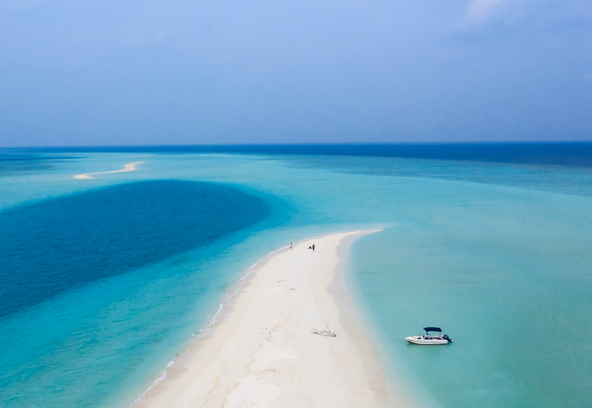Near Six Senses Laamu: white boat on blue sea water during daytime