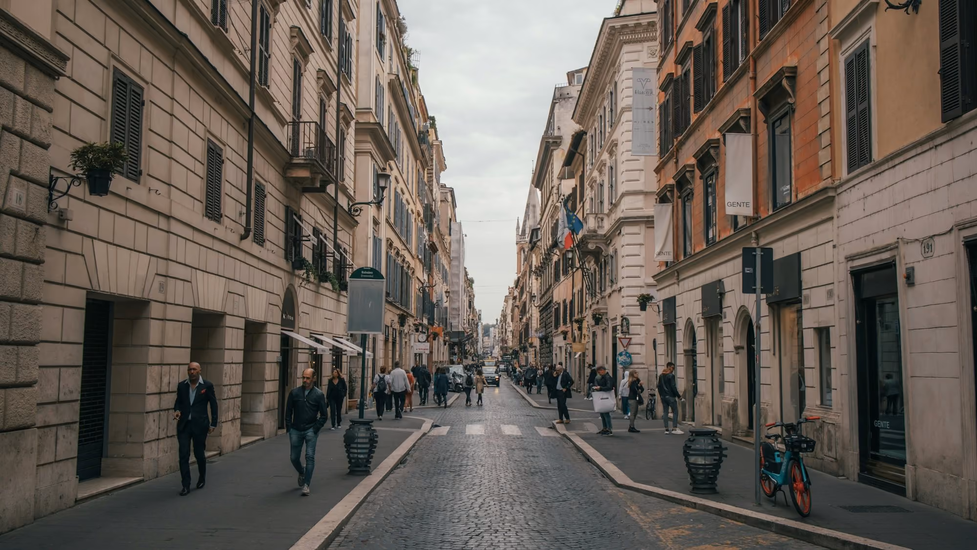 Near Palazzo Roma: a group of people walking down a street next to tall buildings