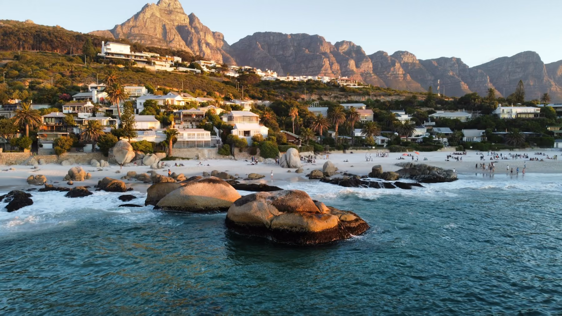Granite boulders and a small beach on Cape Town's Atlantic seaboard under clear skies