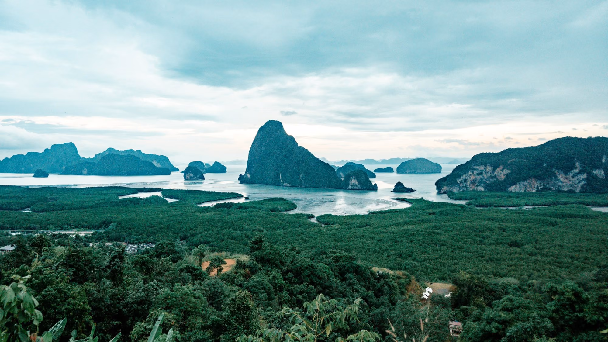 Near Six Senses Yao Noi: an aerial view of an island with a body of water surrounded by trees