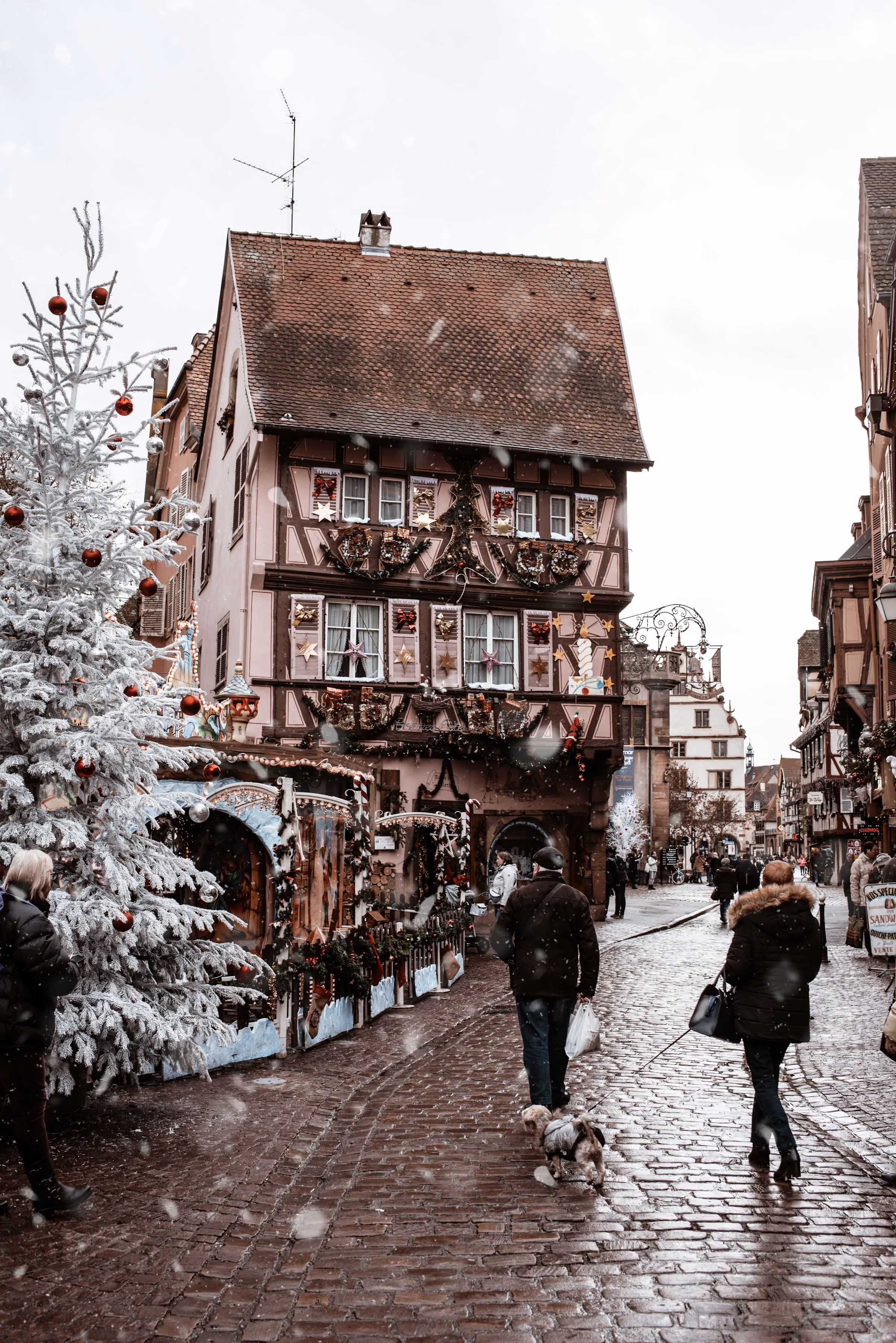 A snowy cobbled street of half-timbered houses in Alsace
